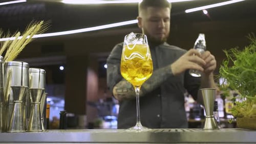 Barkeeper bereitet einen Cocktail in einem Glas zu