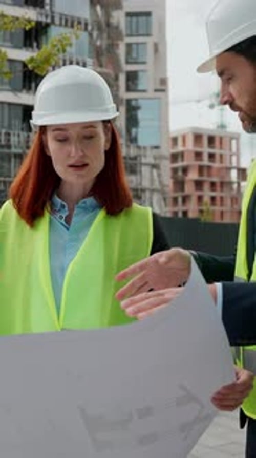 Engineers Reviewing Blueprints at Construction Site