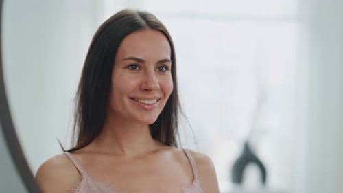 Smiling woman looking at her reflection in mirror