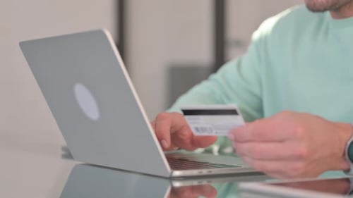 Nahaufnahme eines Mannes, der online mit Kreditkarte einkauft