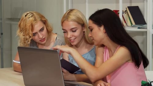 Three Cheerful Female Students Engaged in Collaborative Reading