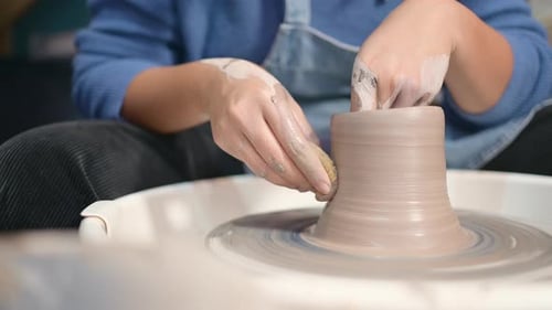 Hands Shaping Clay on a Pottery Wheel