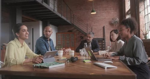 Business People in Meeting Brainstorming at Table in Warehouse conversion