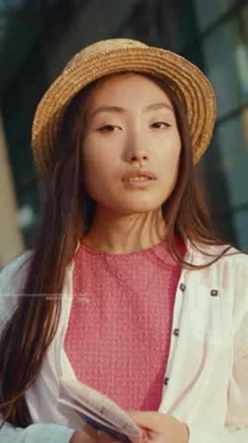 Young Woman Holding Passport in Urban Setting