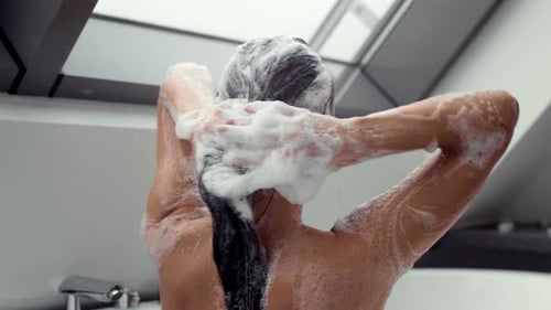 Back View Shot of Young Unrecognizable Woman Washing Her Long Hair While Soaking in Warm Bubble Bath