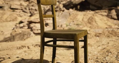 Unique Wooden Chair Placed on Sandy Desert Terrain Under Bright Sunlight