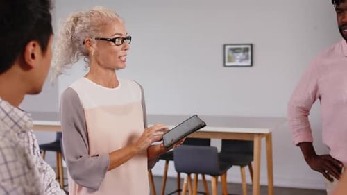 Colleagues Discussing Data on Tablet at Office Meeting