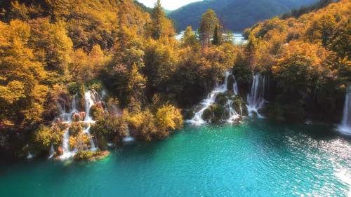 Bosque otoñal dorado y lago de montaña con aguas cristalinas de cascadas. Depósito verde esmeralda. Sunn
