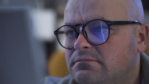 Stock market chart reflected in glasses.