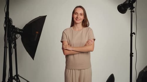 Portrait of a Female Photographer Standing in a Studio with Lighting Equipment