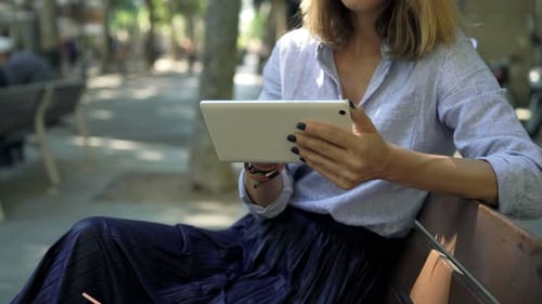 Businesswoman browsing online with tablet computer in modern city environment