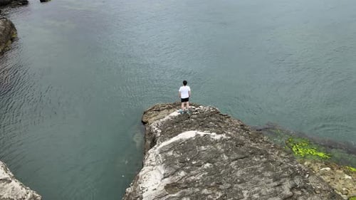 man on cliff watching sea