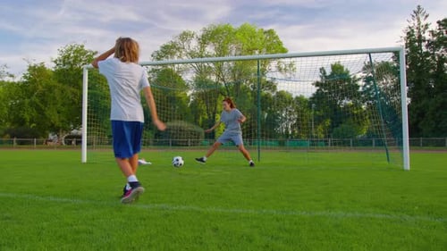 Fußballspielerin spielt Fußball mit ihrem Sohn