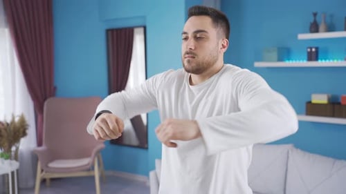 Man Working Out and Stretching Arms Indoors