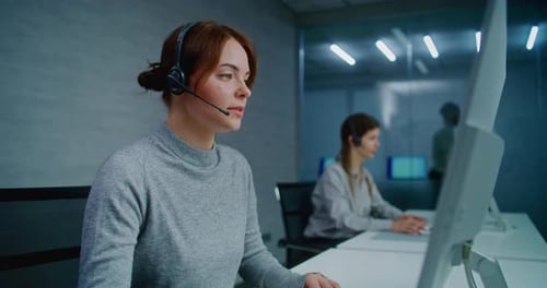 Caucasian Female Hotline Operator Talks on Headset with Customer Works on Computer