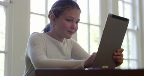 4k video footage of a little girl using a digital tablet while sitting at home