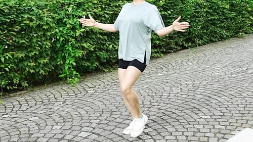 Young Woman in Sportswear is Doing Exercise in City Street Warm Up Before Running or Jogging Outdoor