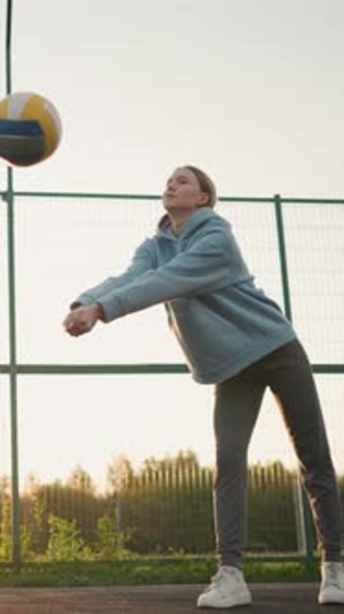 Woman Practices Volleyball Bump Pass in Outdoor Setting