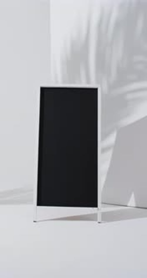 Vertical video of blackboard sign on white stand with copy space on white background