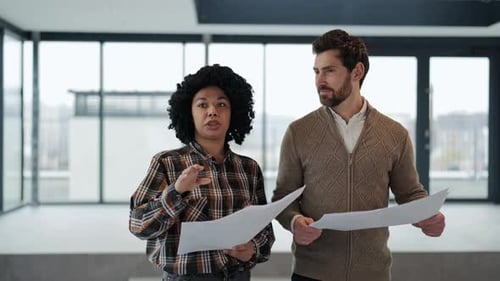 Business People Discussing Blueprints in Modern Office Space