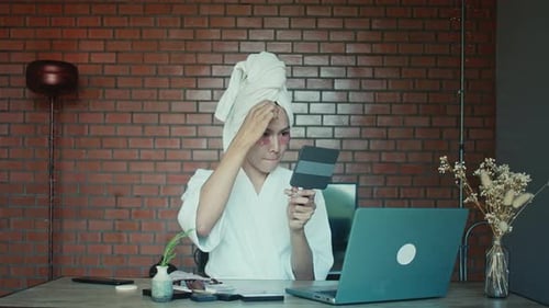 Young Adult Applies Makeup in Home Spa Setting