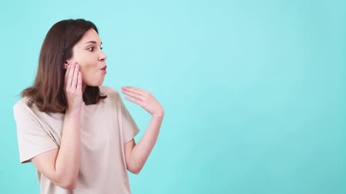 Woman Expressing Excitement and Surprise on Turquoise Background