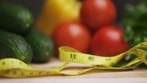 A Side View of Yellow Measuring Tape and Fresh Vegetables on a Wooden Cutting Board Proper Nutrition