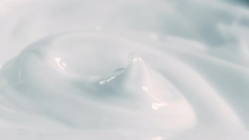 Close Up Shot of Natural Cosmetics Cream with Rotate Effect. Macro White Smooth Facial Cream Texture