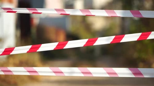 Fita de advertência vermelha e branca balançando no vento