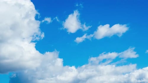 Fluffy White Clouds Drifting Against a Bright Blue Sky