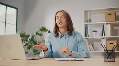 Woman Speaking at Desk in Home Office