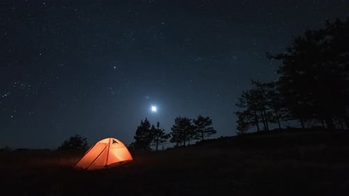 Timelapse des étoiles de la galaxie nocturne et du coucher de lune au-dessus de la tente de camping en forêt