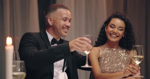 Cheerful Couple Clinking Wine Glasses at Celebration