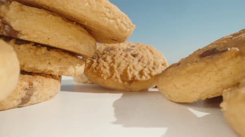 Round cookies with chocolate pieces, scattered on the table,Dolly slider close-up.