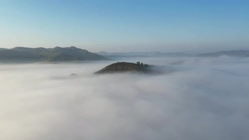 Hill top surrounded by fog in the autumn morning Romanian remote countryside. 4k aerial drone video.