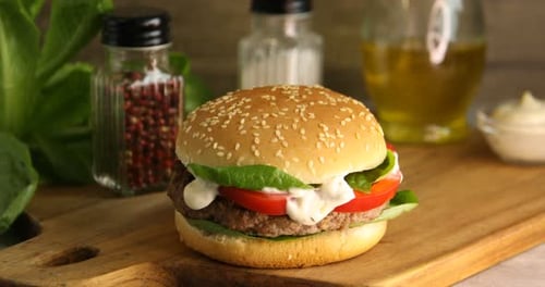Two Delicious Burgers on Wooden Cutting Board