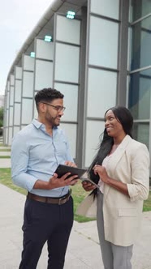 Business People Reviewing Tablet Outside Modern Building