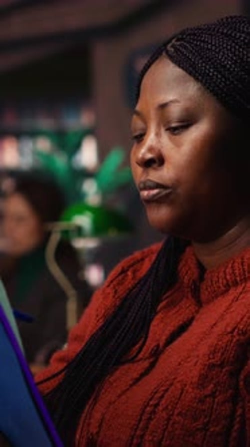 Vertical Video African American Woman with a Book in Hand Studying in a Quiet Library Space