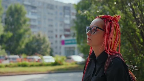 Young Woman with Colorful Braids Standing on City Street