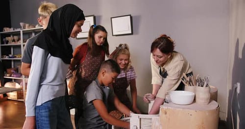 Children Learn Pottery Techniques from Adult Teacher