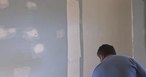 Man Painting Interior Wall Gray With Paint Roller