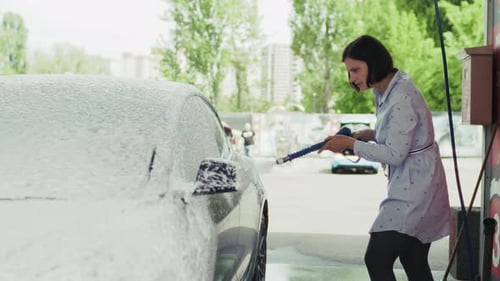 Woman Washing Her Car at Outdoor Car Wash