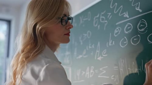 Teacher Hand Writing Formulas on Blackboard School Closeup Woman Teaching