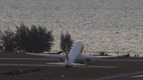 Airplane Taking Off Over the Ocean at Sunrise