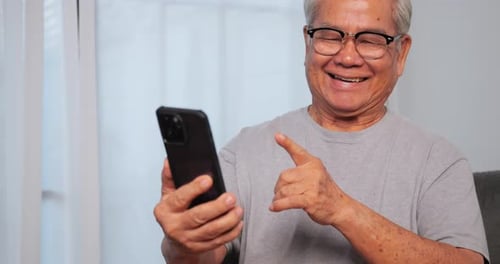 Senior Man Happily Video Calling on Smartphone