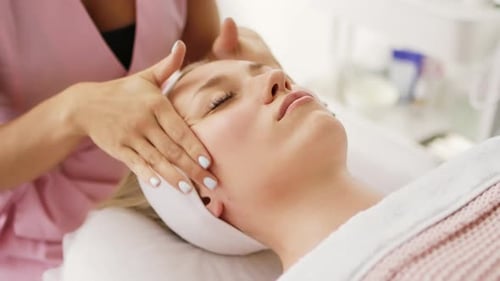 Woman Receives Facial Massage in Spa Setting
