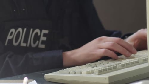 Police on keyboard filing reports close up HD