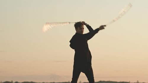 Man Spins Flaming Torches at Sunset
