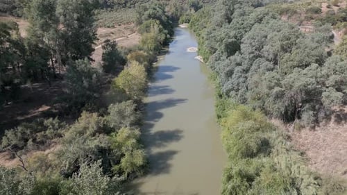 A leisurely drone aerial above the Guadalquivir River in Marmolejo, Jaén province, Spain, showcasing