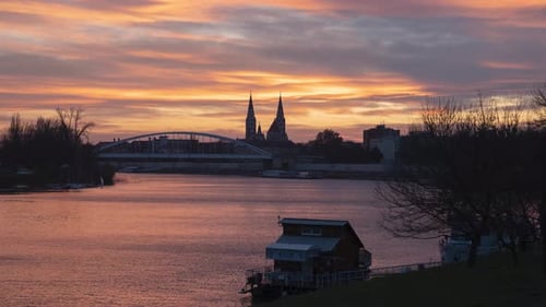 Breathtaking twilight time lapse of river Tisza in Szeged. Cityscape with Downtown Bridge and Votive